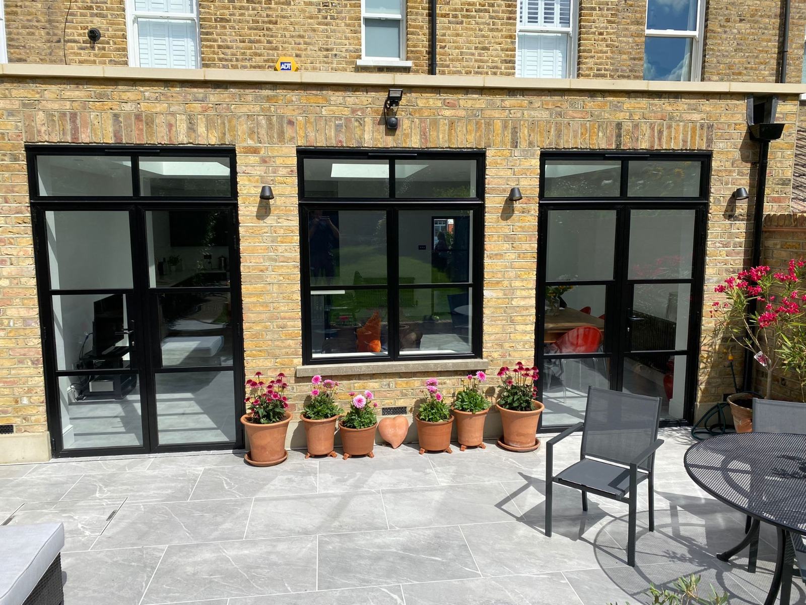 Black aluminium doors and windows fitted to the ground floor of a London brick townhouse