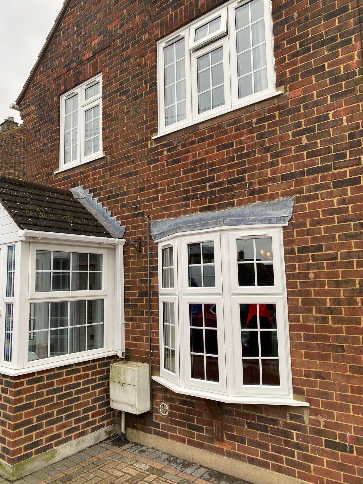 New white uPVC bay and casement windows with Georgian glazing bars fitted to a red-brick Kent home