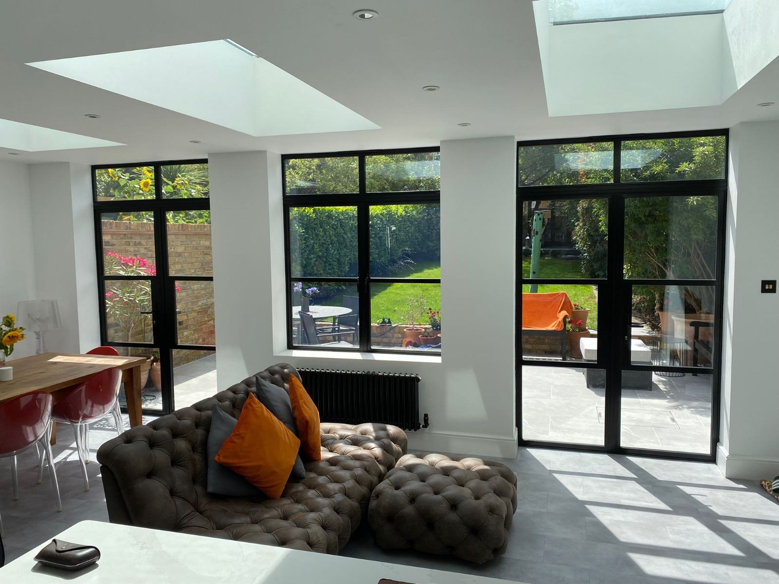 Modern kitchen extension interior with flat rooflight skylights and full-height aluminium windows
