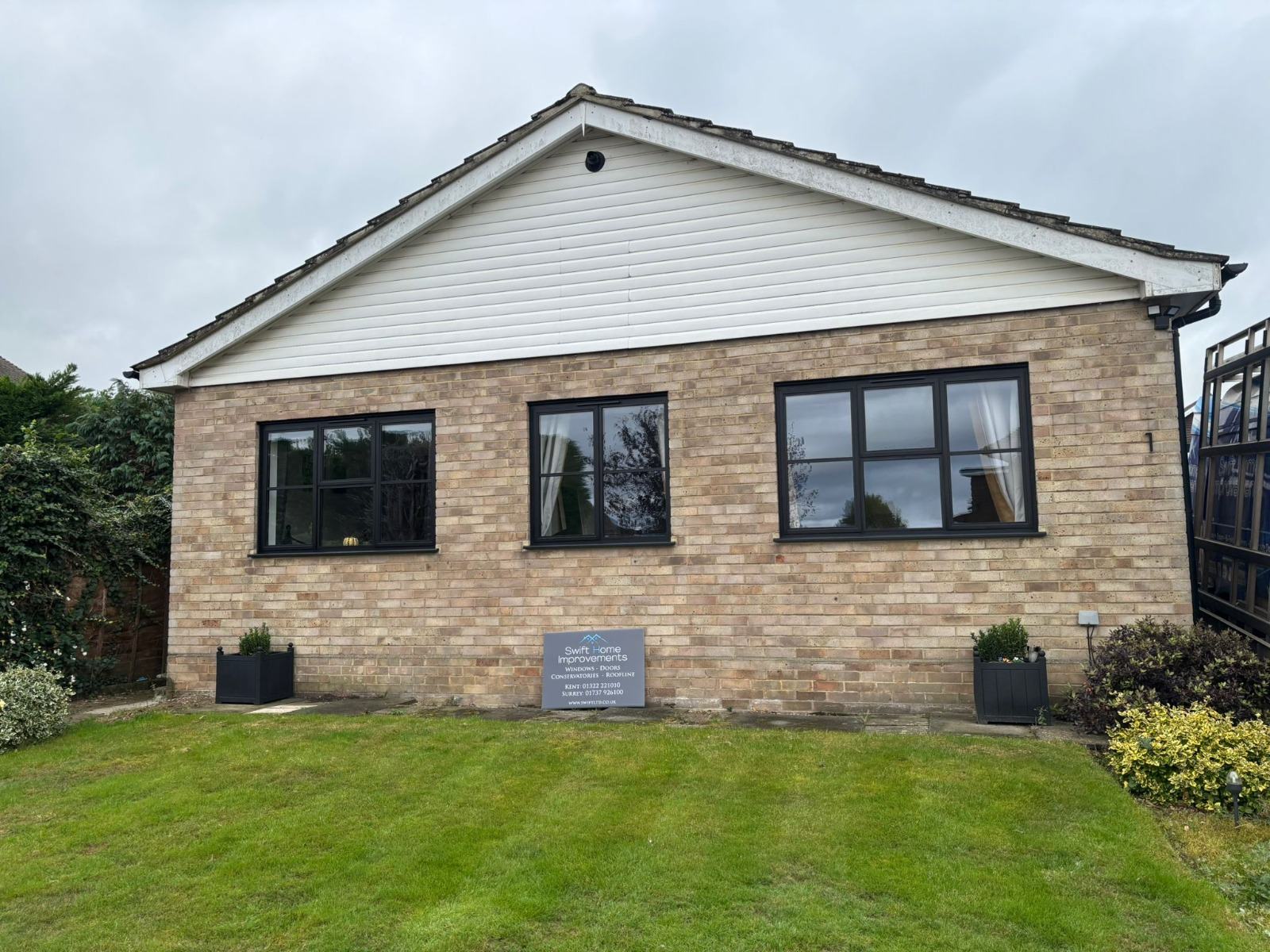 Detached bungalow with three new anthracite grey aluminium casement windows installed by Swift Home Improvements