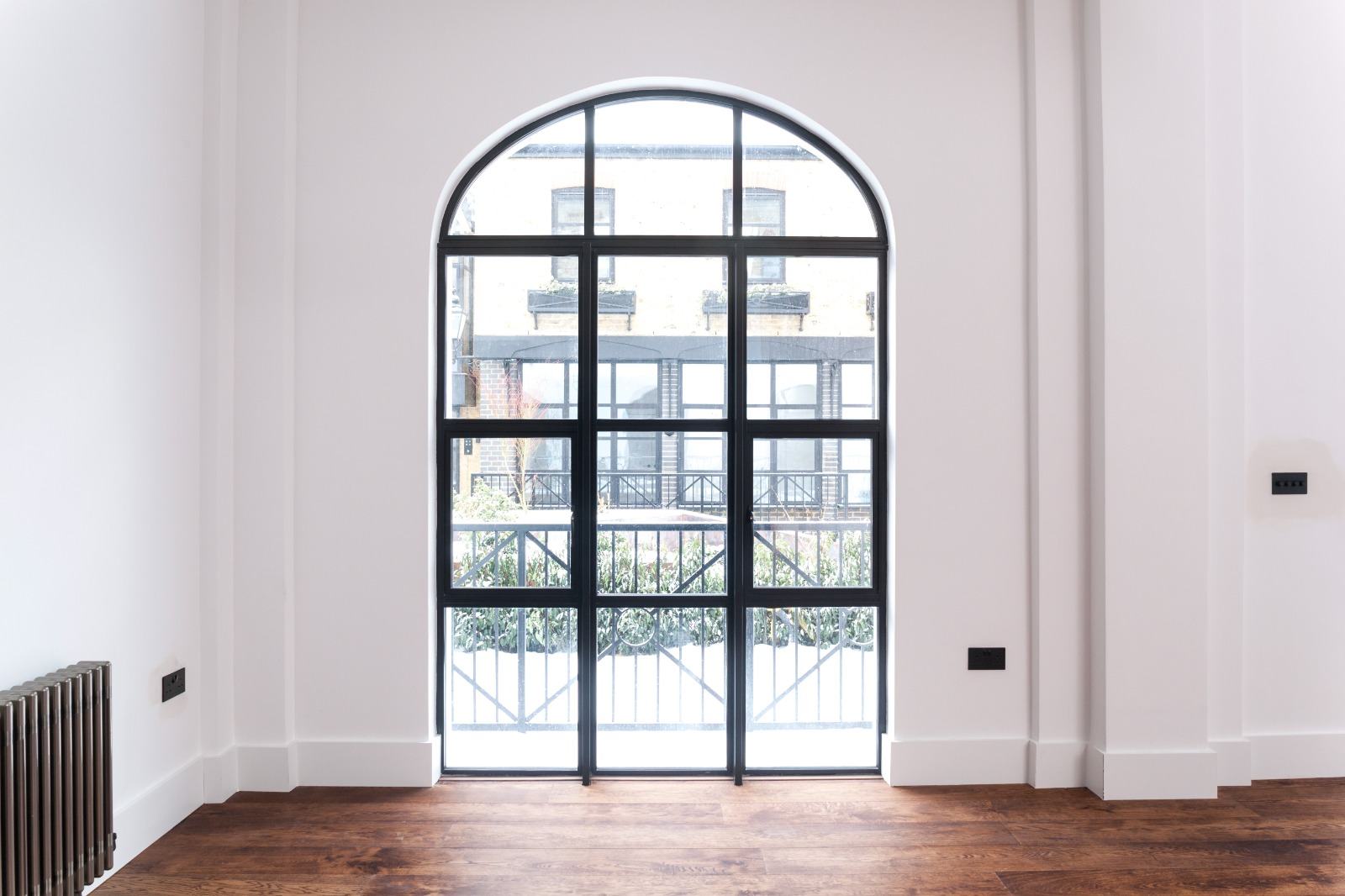 Arched black aluminium Crittall-style internal glazed door installed in a period property